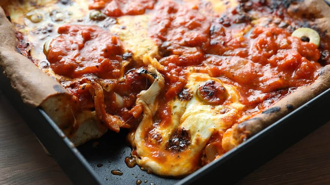 Detroit-style square pizza in an authentic steel pizza pan